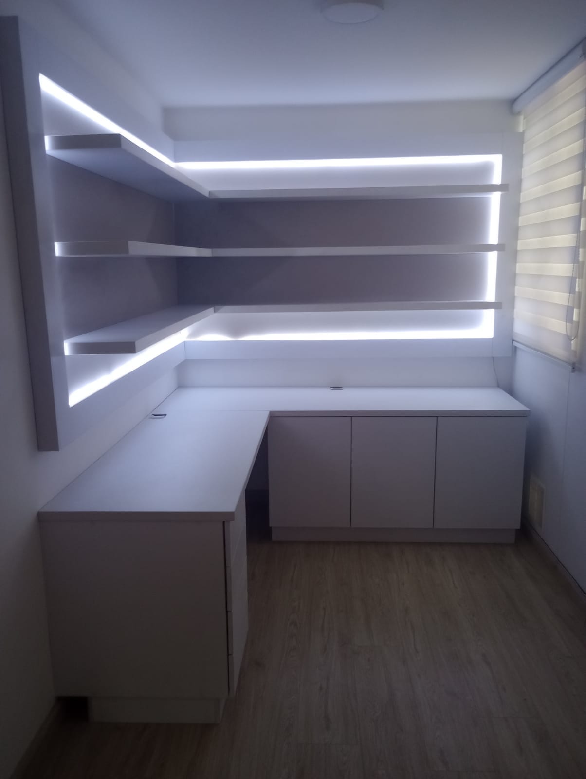 Mobiliario con repisas iluminadas y escritorio a medida BEH